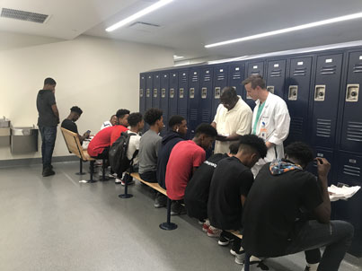 A bunch of students sitting in line with teachers in front