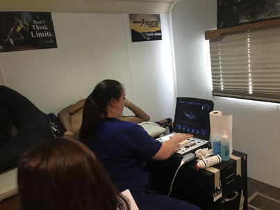 A woman sitting on a desk with her laptop on the table