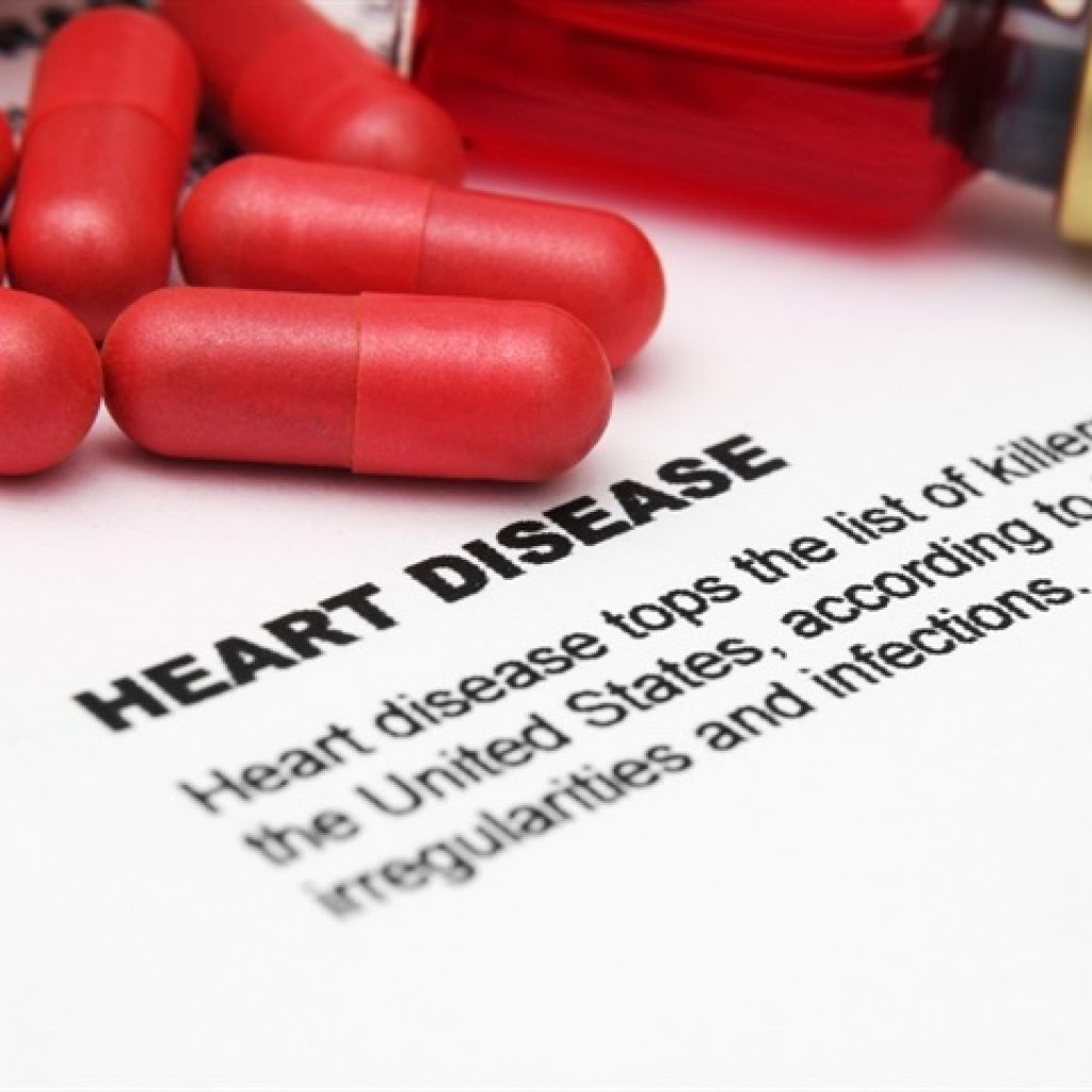 heart disease written on a paper with red capsules kept on